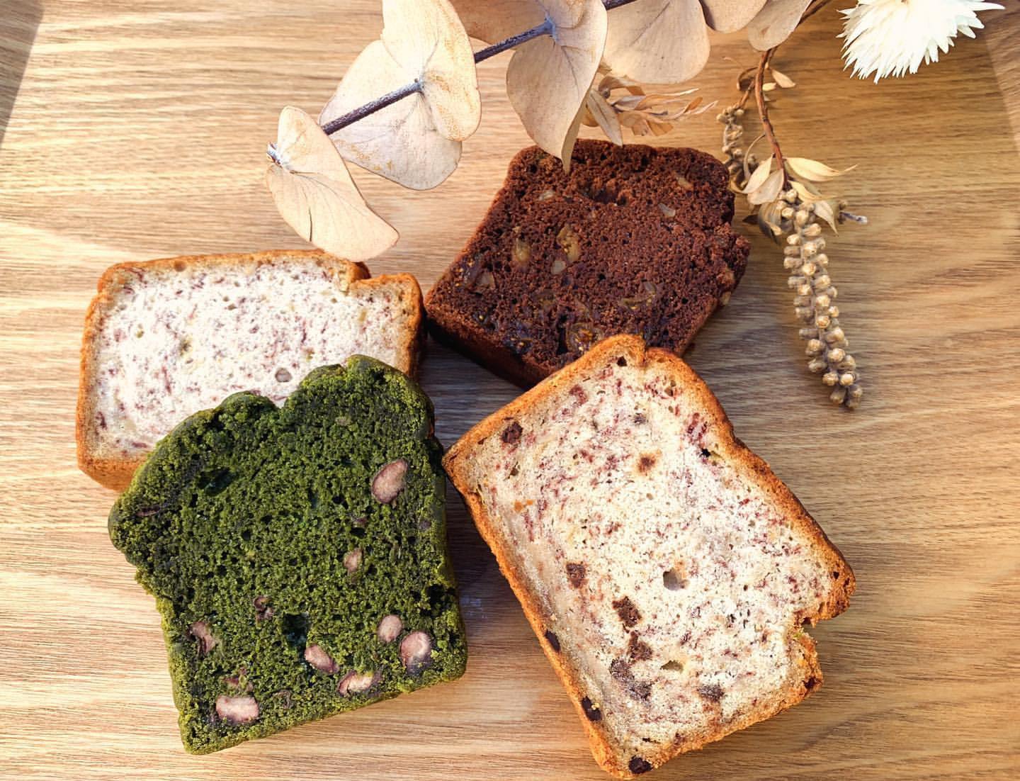木のボードに並べた米粉パウンドケーキ4種（抹茶と小豆、ココアとクルミ、バナナ、チョコチップ）