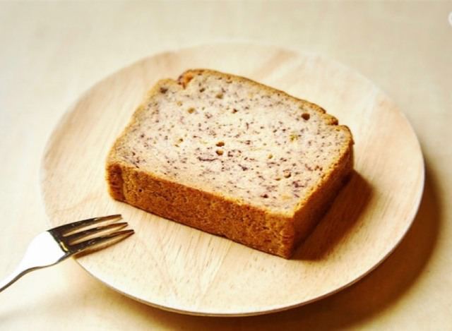 木の皿にのせた、ひと切れのバナナの米粉パウンドケーキとフォーク